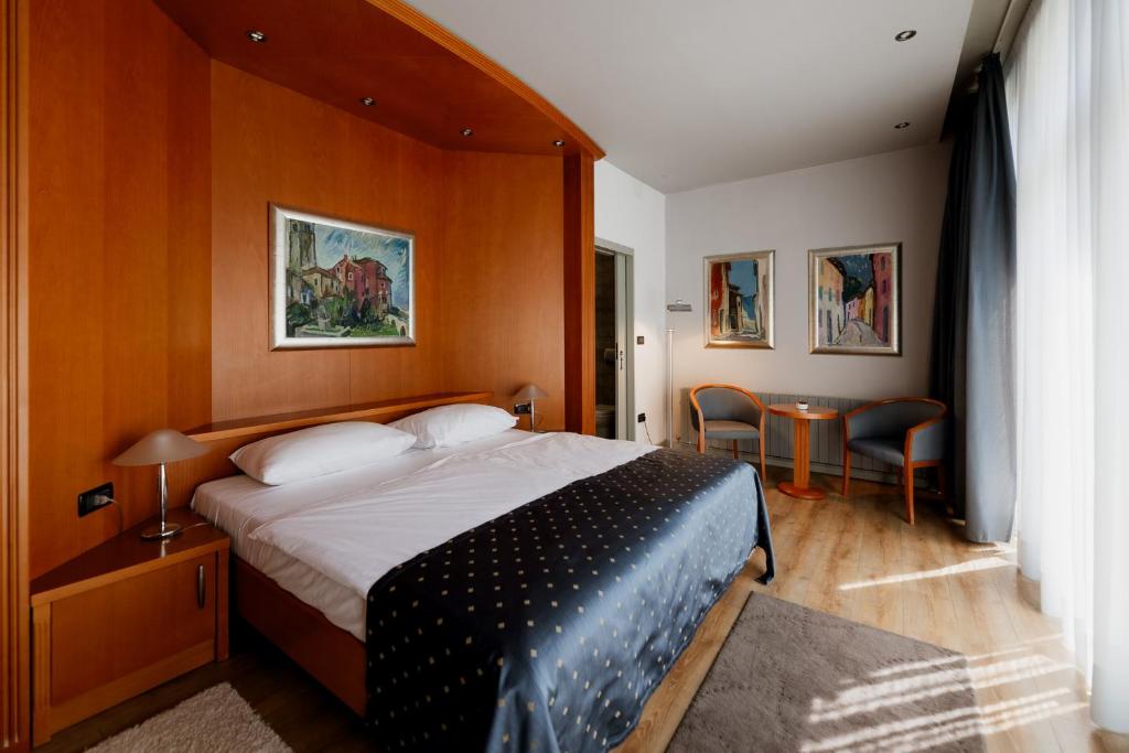 莫托文喀什特精品酒店的一间卧室配有一张床和一张桌子及椅子