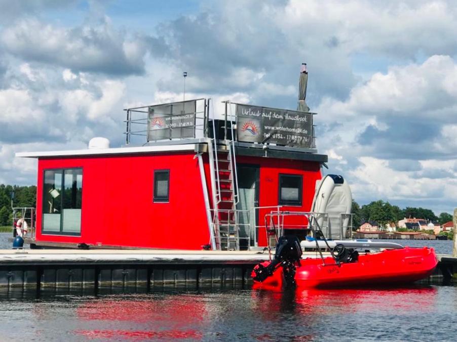 菲尔斯滕贝格Schwimmendes Ferienhaus "Enola" Ihr Riverloft auf der Havel的一艘红色的船停靠在码头