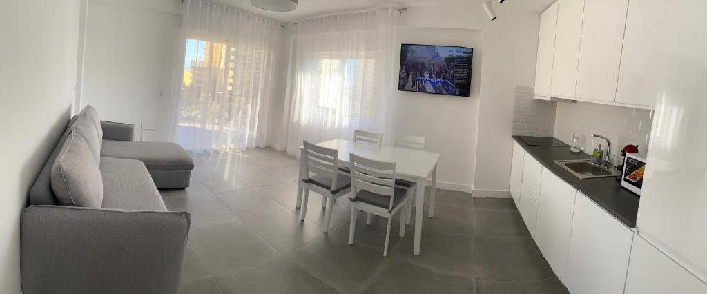 滨海罗克塔斯Apartamentos La Gaviota的厨房以及带桌子和沙发的客厅。