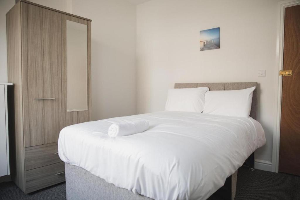 莱斯特Luxury City Rooms in Leicester的卧室配有一张带白色床单和枕头的大床。