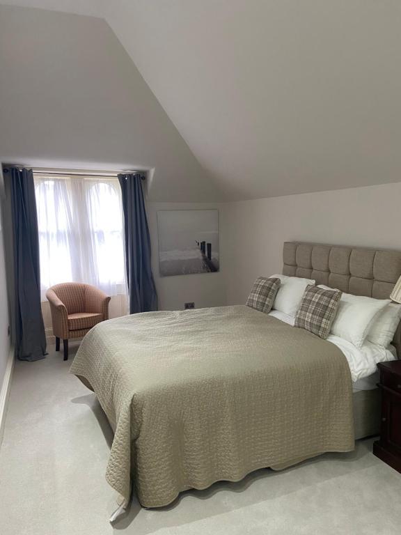 爱丁堡Merchiston Residence的一间卧室配有一张大床和一把椅子