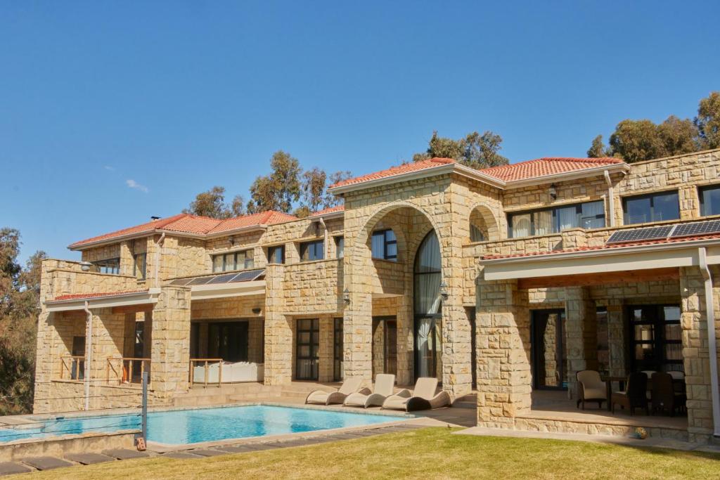 哈里史密斯Mseleku Villa的一座带游泳池的大型石屋