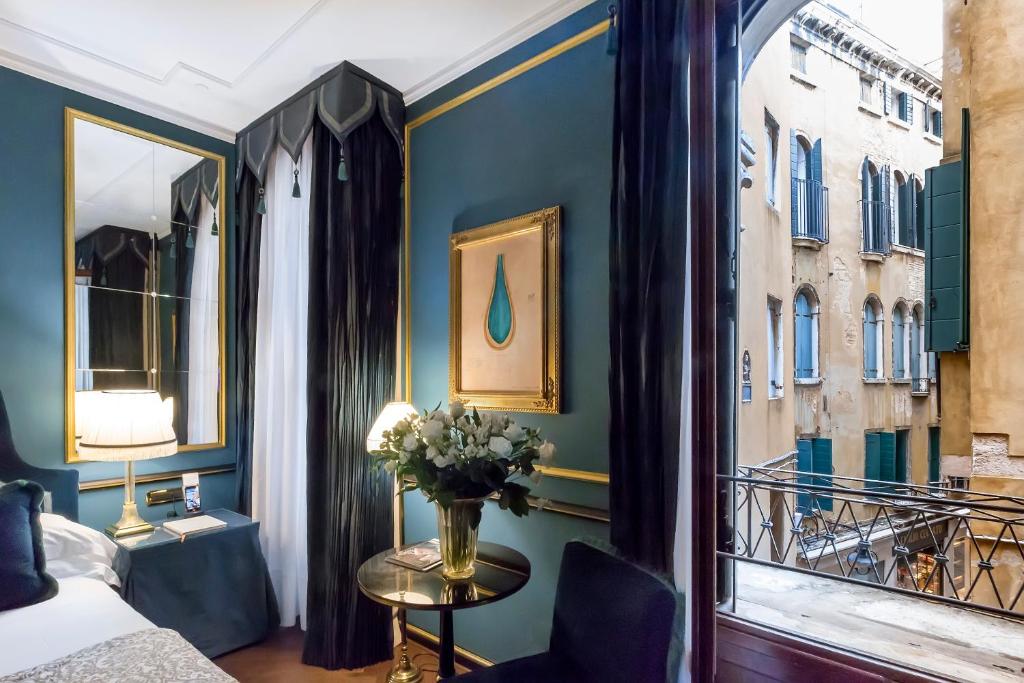 威尼斯锦绣威尼斯 - 星际连锁酒店的卧室,窗户旁的桌子上放着花瓶