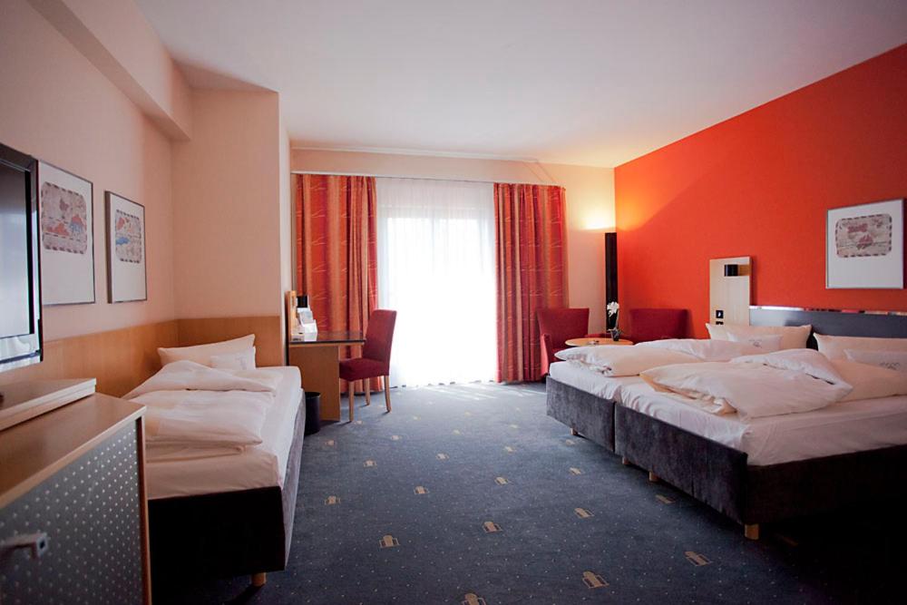 施特劳宾塞热西恩托尔酒店的酒店客房设有三张床和窗户。