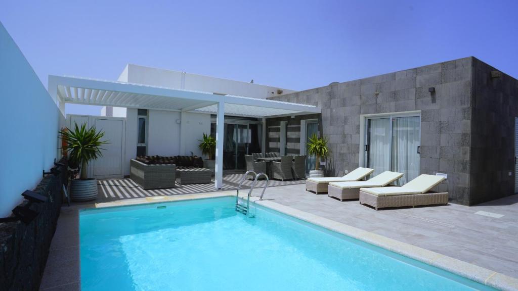 普拉亚布兰卡Villa Patricia Playa Blanca的房屋旁带游泳池的房子