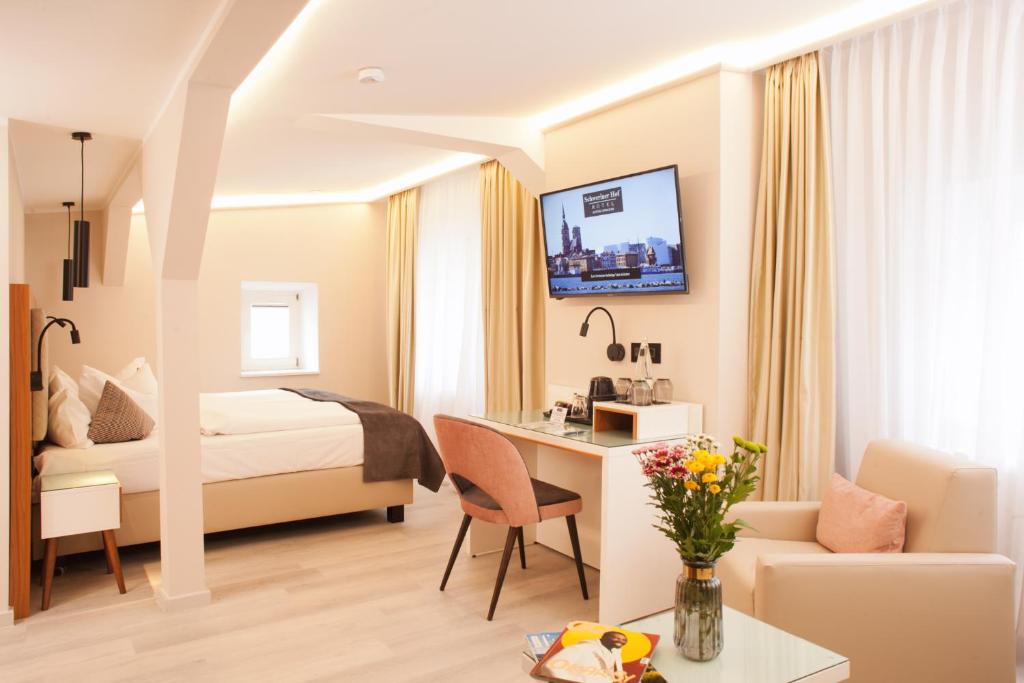施特拉尔松德史威林霍夫酒店的配有一张床和一张书桌的酒店客房