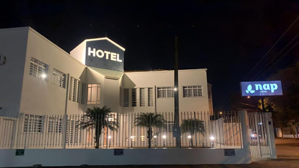 蓬塔格罗萨Nap Hotel的一家晚上在上面标有标志的酒店