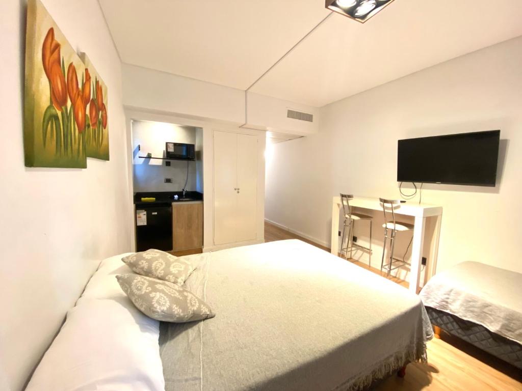 布宜诺斯艾利斯Apart hotel Ciudad de Bs As的一间卧室配有一张床和一台平面电视
