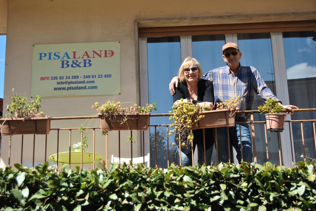 比萨匹萨兰德住宿加早餐酒店的男人和女人站在 ⁇ 上,植有盆栽植物