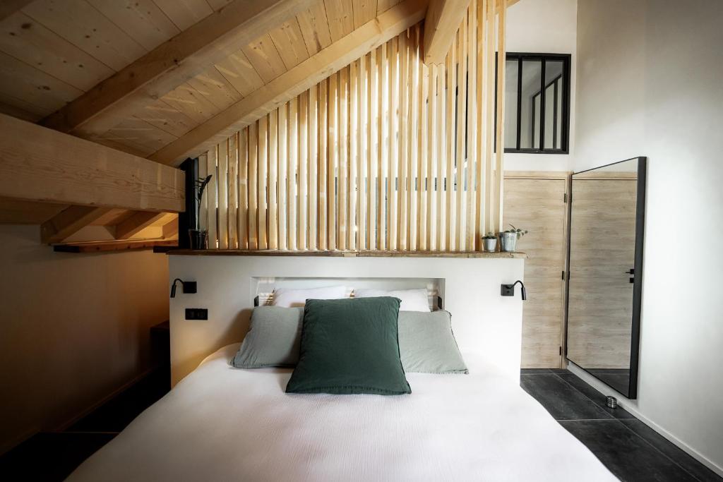 普雷芒翁La Loge de la Dolarde - Chambre Ouest的一间卧室配有一张带绿色枕头的床