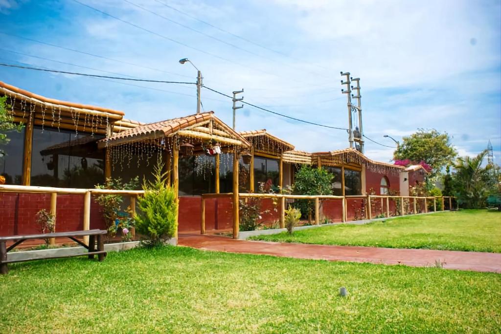 巴兰卡Bungalows Payancas de Tato的草上有栅栏的房子