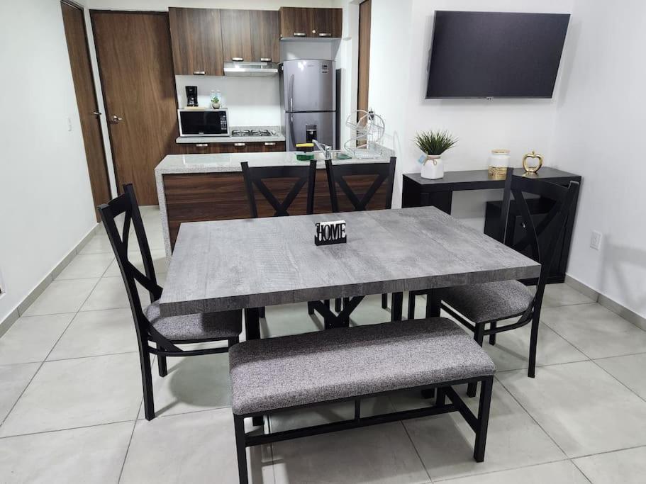 瓜达拉哈拉Amplio departamento con alberca的餐桌和椅子以及厨房