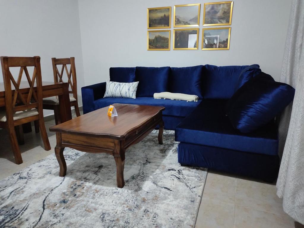 KerichoZoe Homes Oak Villa Apartment 1 and 2 Bedroom 201的客厅配有蓝色的沙发和茶几
