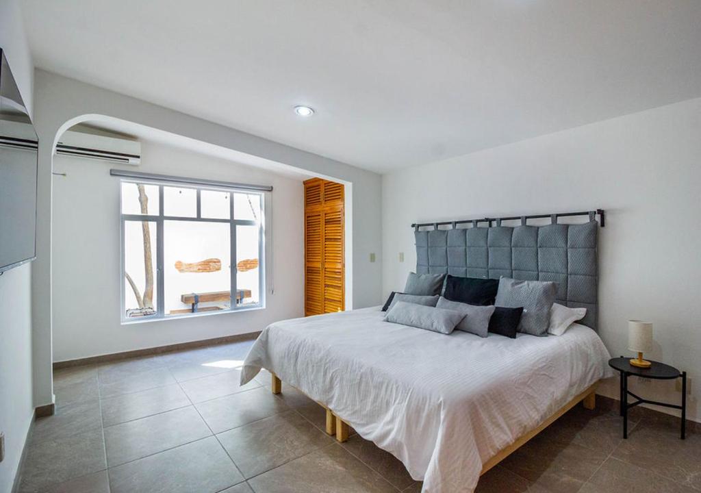 瓦哈卡市Casa InHome, your home at Oaxaca的一间卧室设有一张大床和一个窗户。