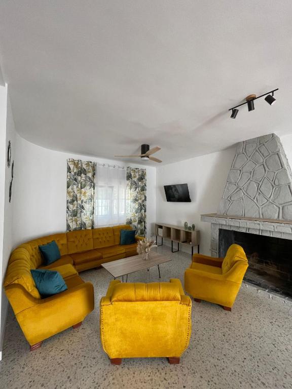 CazalegasVilla Paraiso的客厅配有黄色家具和壁炉