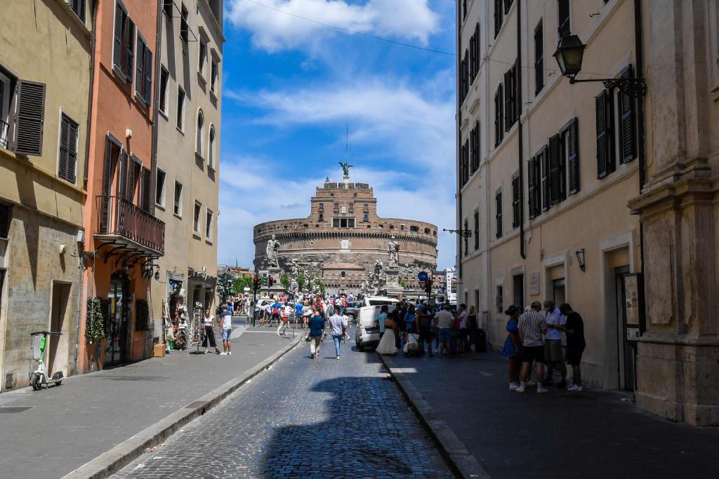 罗马Castel Sant'Angelo Apartments - Exclusive & Luxury的一群人沿着街道走着,街道上有许多建筑