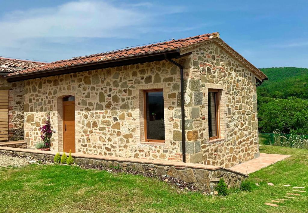 布奇内La Casetta Biricocolo的一座带草地庭院的小石头房子