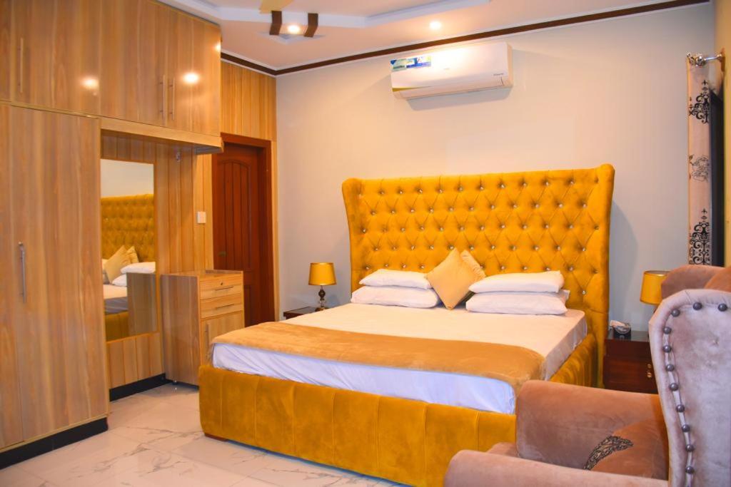 伊斯兰堡Britannia House near Islamabad International Airport and Motorway的一间卧室配有一张大床和一把椅子