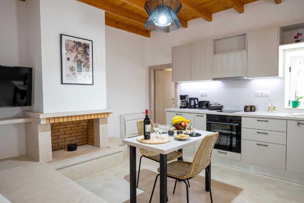 古卡斯特隆Klelia's Apartments的厨房配有桌椅和壁炉。