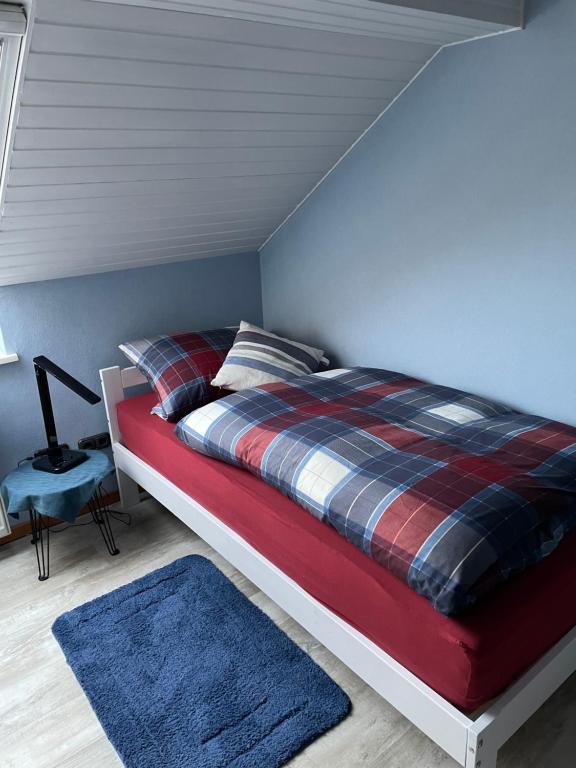 布利斯卡斯特尔Gästehaus Am Radweg的一间卧室配有一张带铺着地毯和蓝色地毯的床。