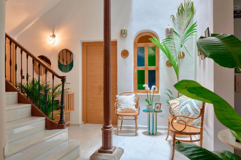 格拉纳达Casa Vestali的走廊上设有楼梯、椅子和植物