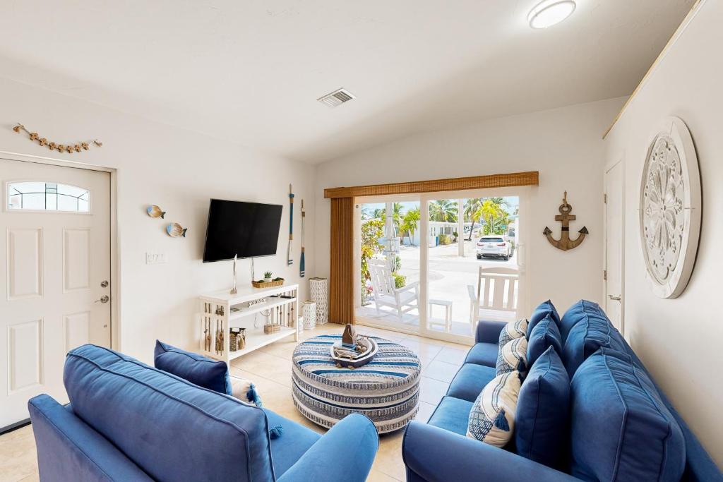 基克罗尼海滩Coastal Charm Hideaway的客厅配有蓝色的沙发和电视