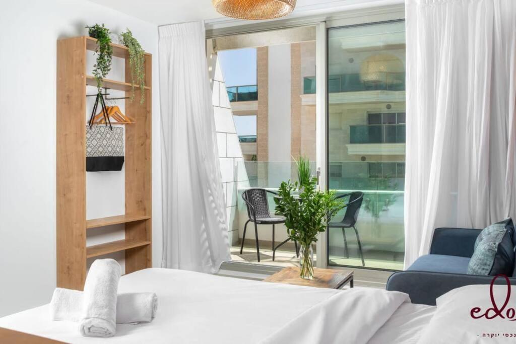 埃拉特Luxury living 100 meter from the beach - by Edom的一间卧室设有一张床和一个美景阳台