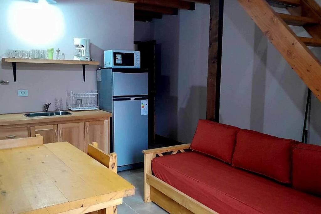 圣卡洛斯-德巴里洛切Cabaña en Villa Los Coihues的厨房配有红色沙发和蓝色冰箱
