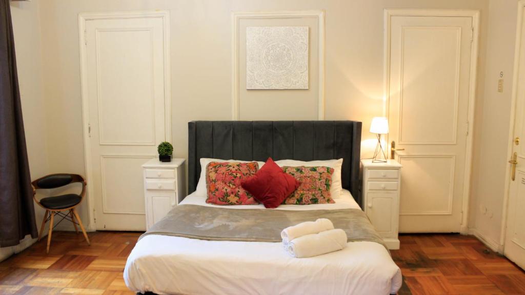 圣地亚哥BBCasita的一间卧室配有一张带黑色床头板和红色枕头的床。