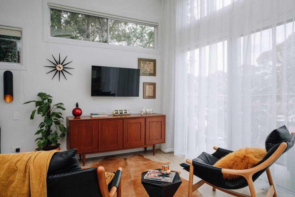 特里格尔Retro Retreat - by Coast Hosting的客厅配有电视、沙发和椅子