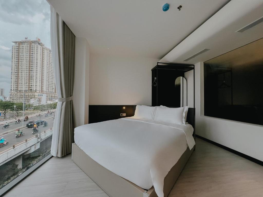 胡志明市The Concept Hotel HCMC- District 1的卧室设有一张白色大床和大窗户
