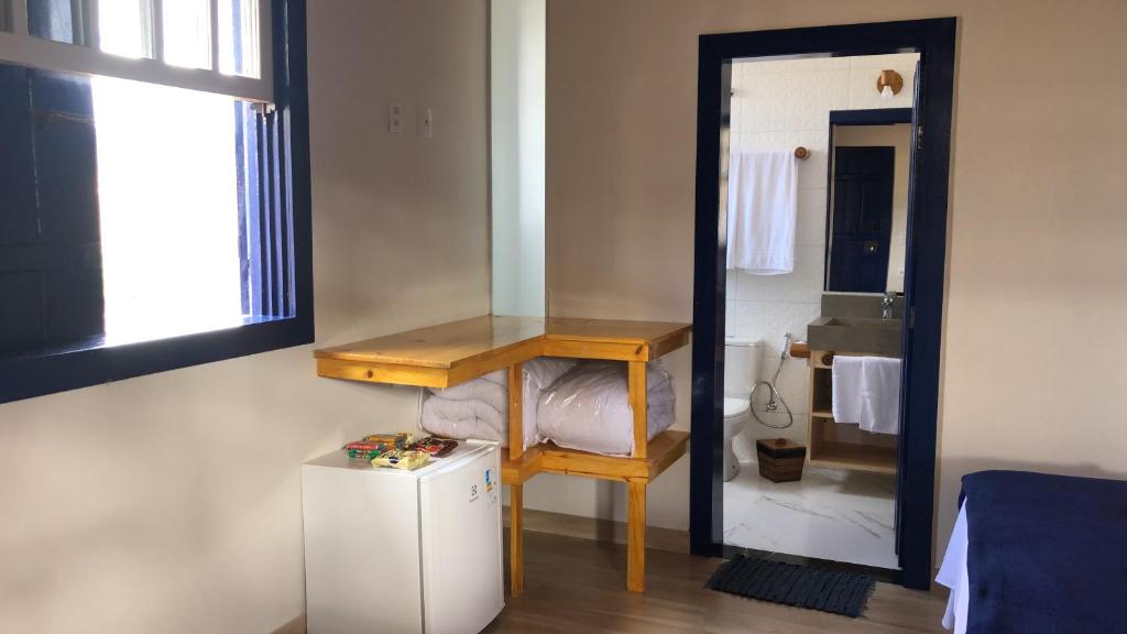 迪亚曼蒂纳Estância do Biribiri的客房设有镜子、桌子和小冰箱