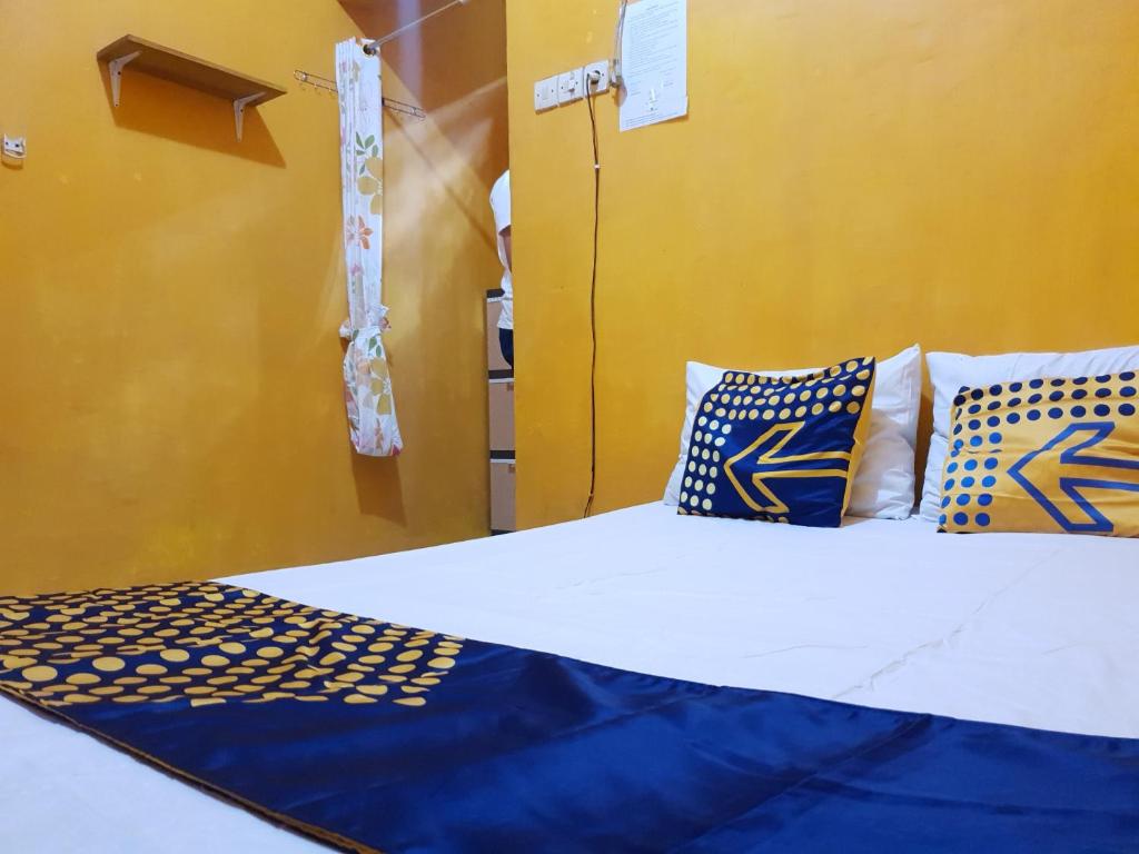 外南梦SPOT ON 92857 Kos Haji Jakfar Syariah的一张带蓝色和黄色枕头的床