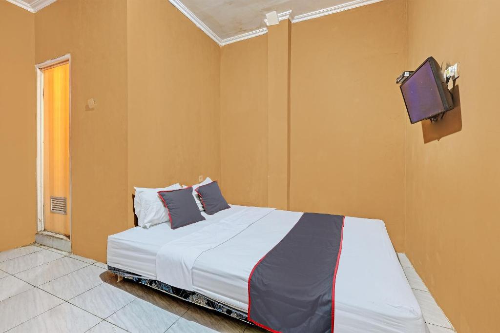 三宝垄Collection O 92864 Mitra Residence的卧室配有一张床铺,墙上配有电视
