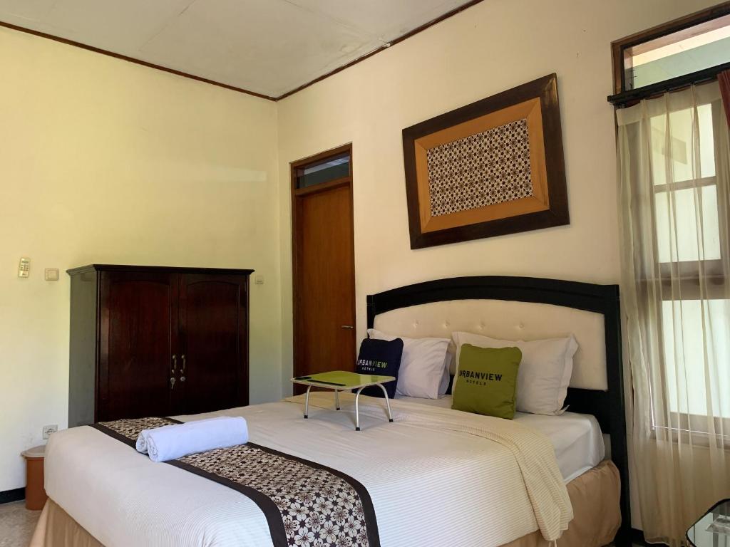 日惹Urbanview Sasono Putro Condoongcatur by RedDoorz的一间卧室设有两张床和窗户。