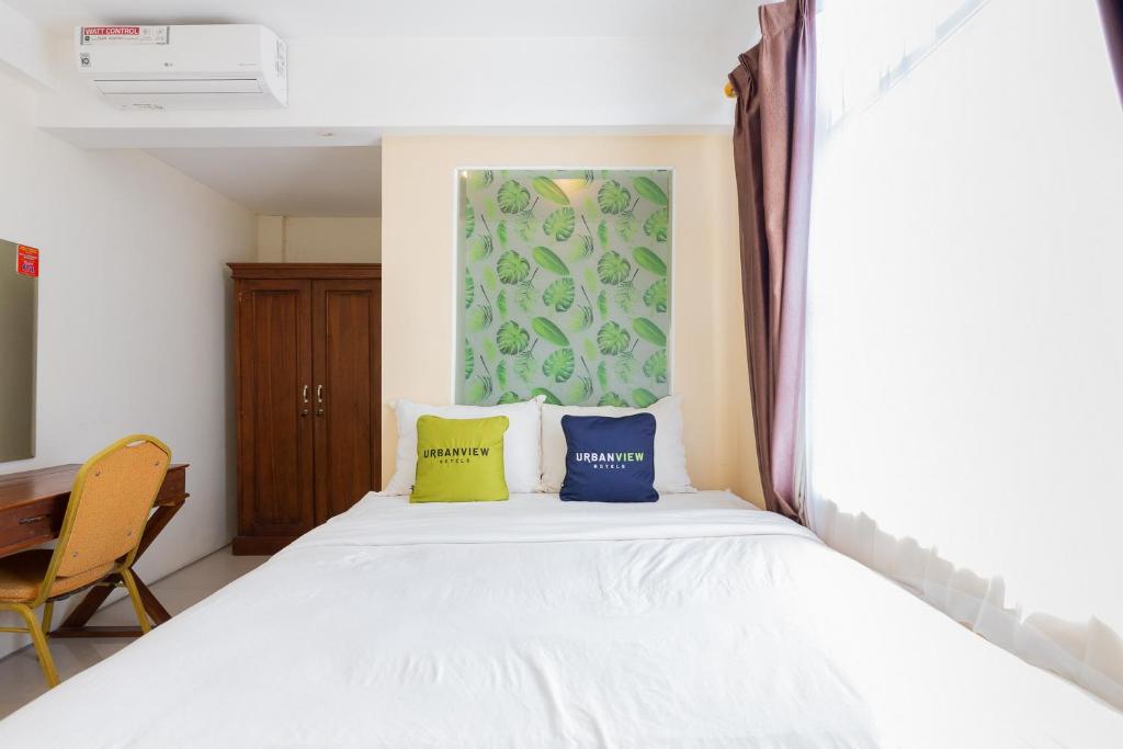 泗水Urbanview Erga Family Residence Syariah Surabaya的卧室配有白色的床和2个枕头