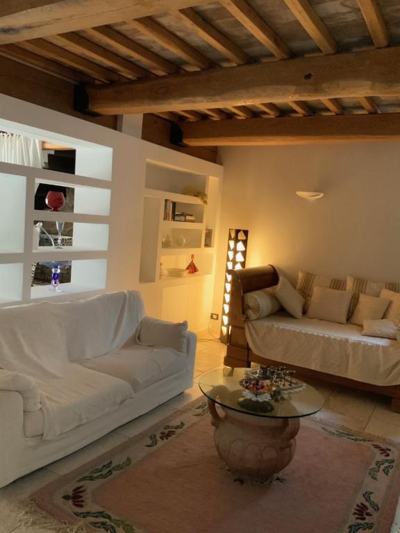 蒙特普齐亚诺La casa dei caprioli appartamento in casale的客厅配有2张白色沙发和1张桌子