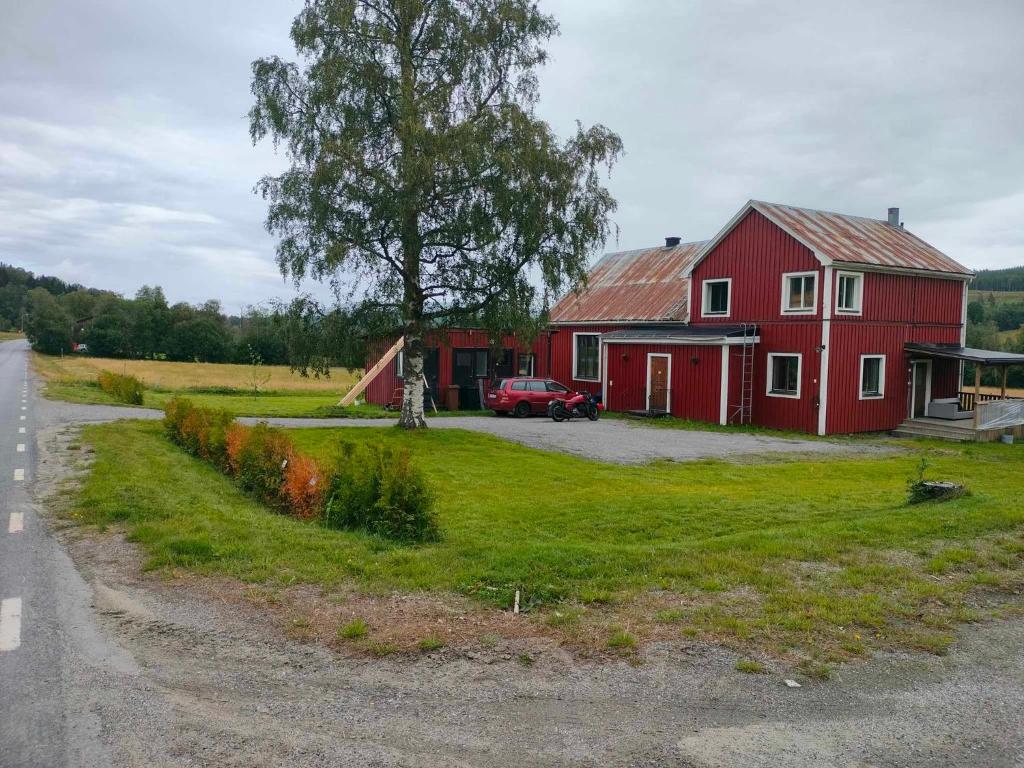 Vackert naturnära i Höga Kusten的坐在路边的红谷仓