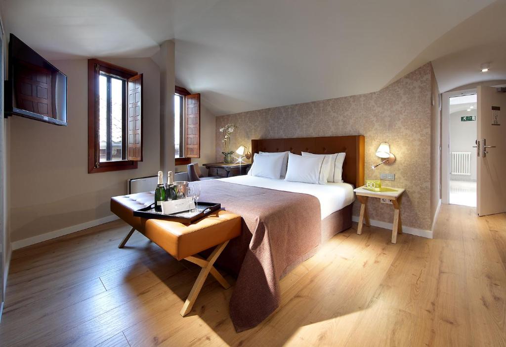 塞哥维亚埃克卡萨德洛斯丽娜杰酒店的酒店客房配有一张床、一张书桌和一张西德西德西德西德床
