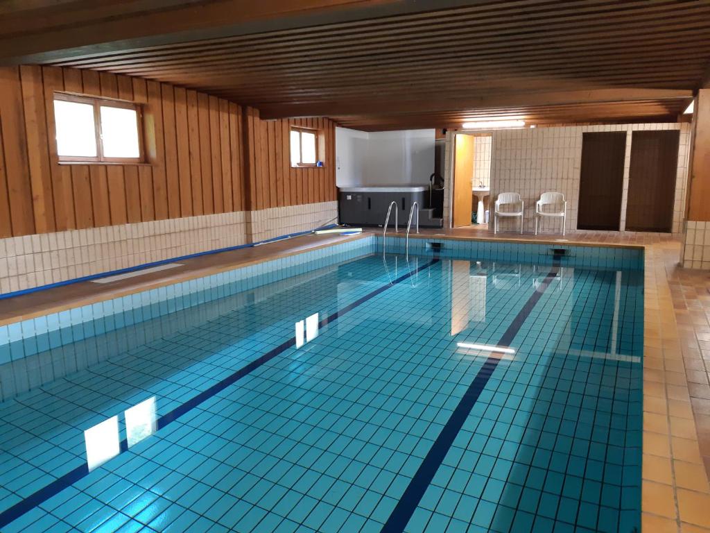 穆尔巴赫Hotel-Spa & Restaurant Logis Domaine Langmatt的铺有蓝色瓷砖的大型游泳池