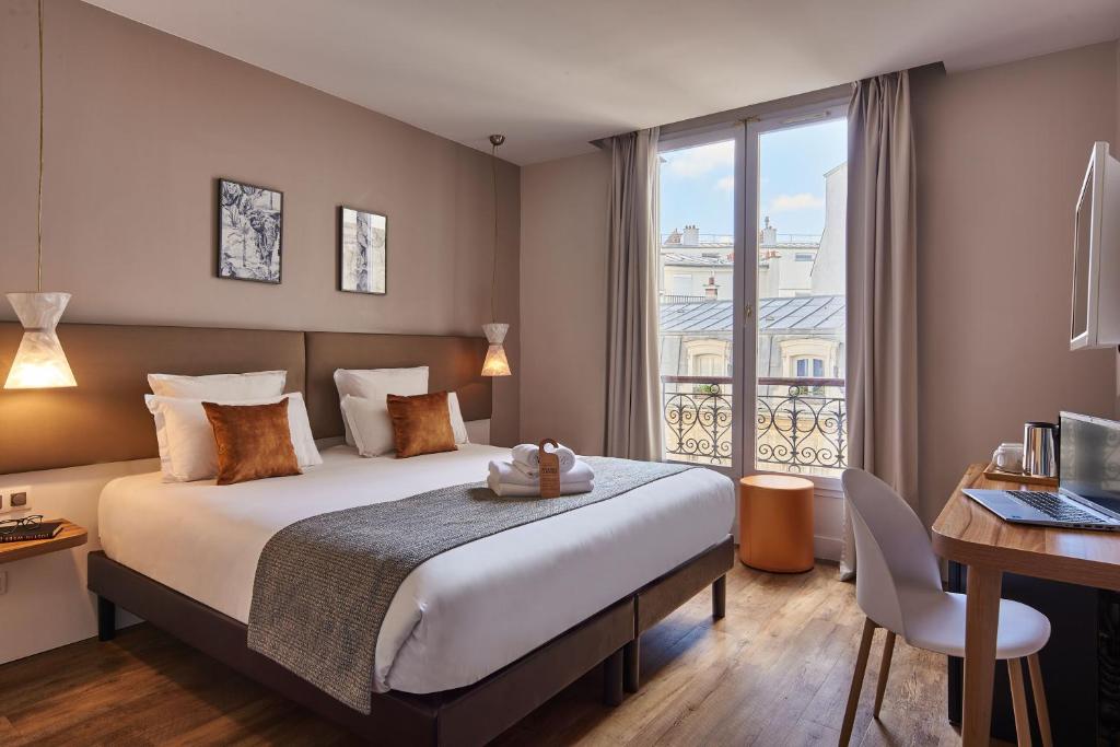 巴黎快乐文化马真塔38酒店的配有一张床、一张书桌和一扇窗户的酒店客房