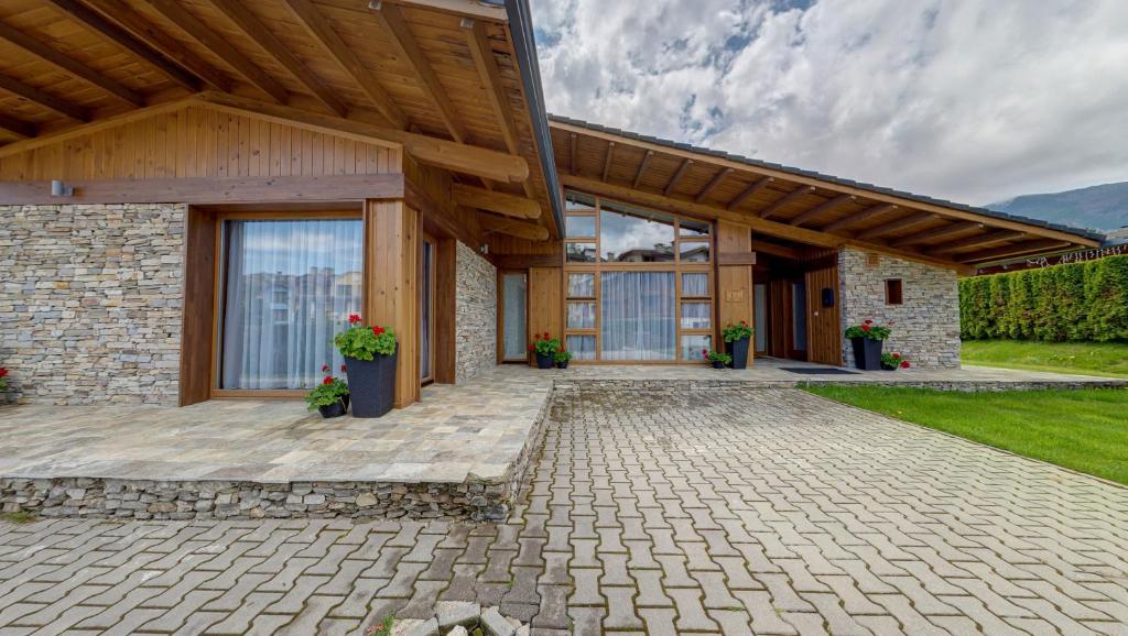 拉兹洛格Boutique Holiday Pirin Golf的一座带石头庭院和木屋顶的房子