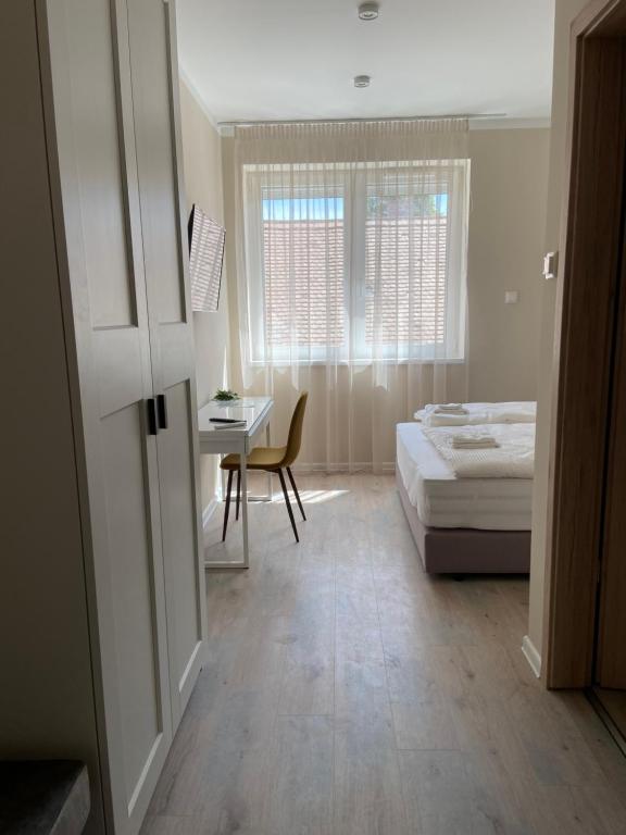 佩奇H30 Apartman的一间卧室配有一张床、一张书桌和一个窗户。