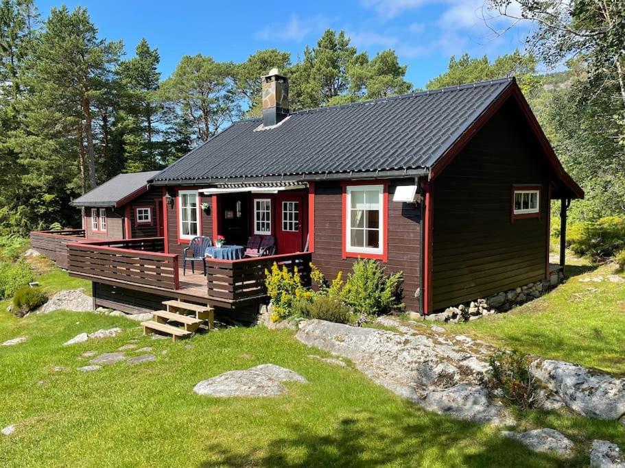 莫尔德Sjarmerende hytte omgitt av vakker natur的红色小屋设有门廊和甲板