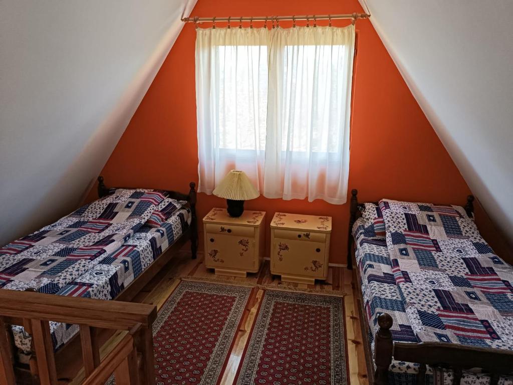 巴伊纳巴什塔Vila Mitrović的阁楼卧室设有两张床和窗户。