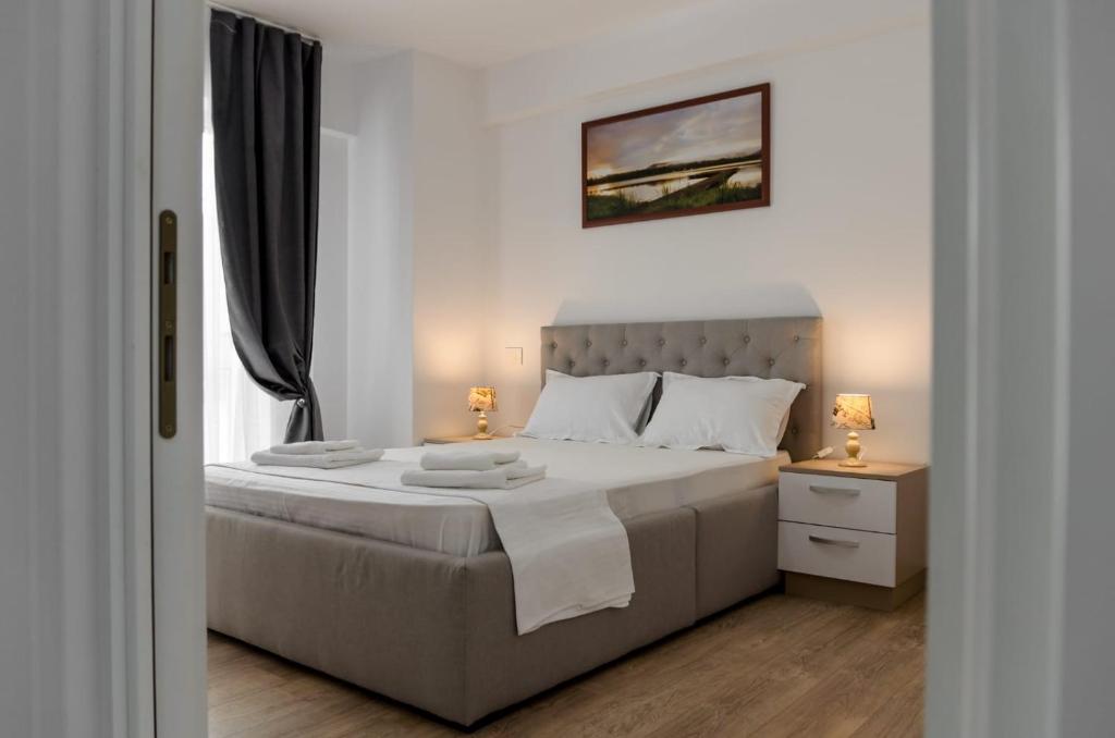 雅西Luxury Studios & Apartments Newton by GLAM的白色卧室配有一张带两盏灯的大床