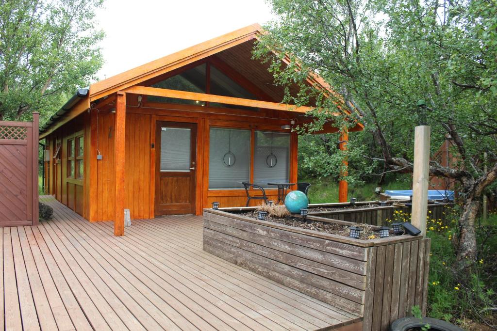 胡萨费尔Relaxing and cozy cottage with hot tub的小木屋设有1个带桌子的甲板