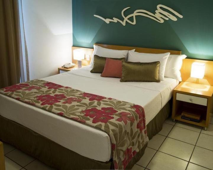 维多利亚Praia do Canto Apart Hotel - Apto 405 - Varanda Lateral com Vista Mar的一间卧室设有一张大床和绿色的墙壁