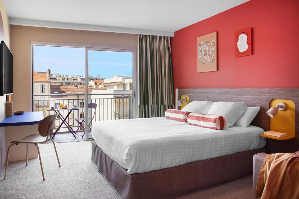 戛纳艾博利亚酒店的一间卧室设有一张红色墙壁的大床