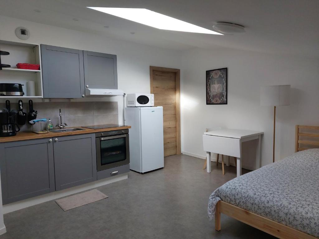 Corny-sur-MoselleStudio mezzanine tout confort的厨房配有床和白色冰箱
